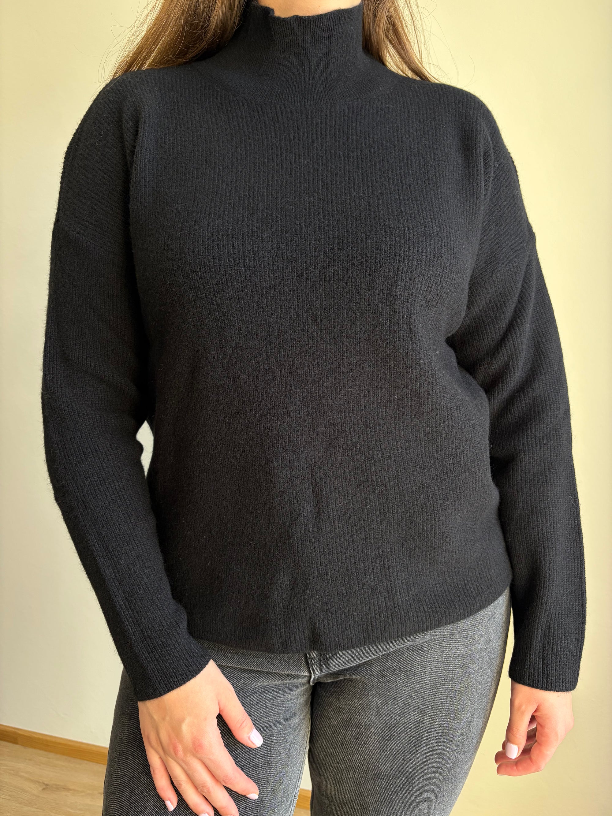 Pulover Velus – črna barva, visok ovratnik, 100 % merino volna, na modelu, pogled od spredaj